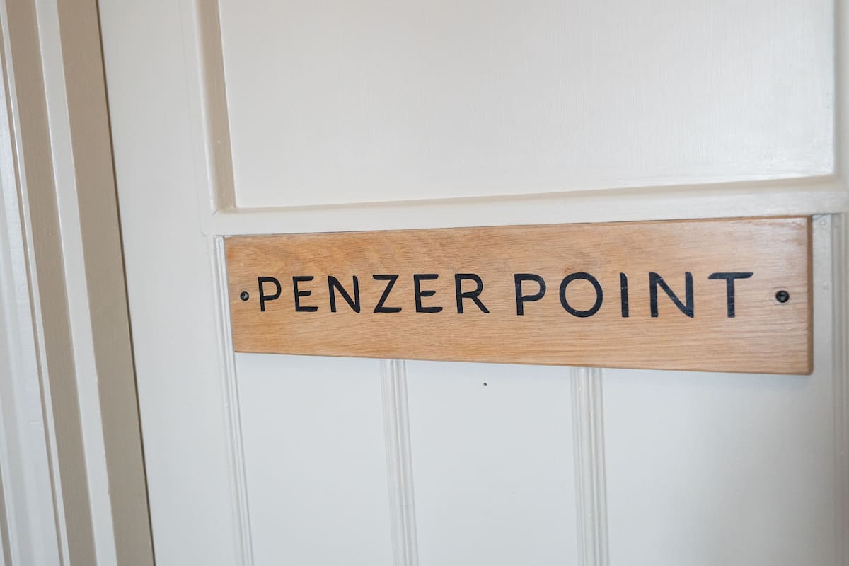 A wooden sign with the text "PENZER POINT" on a white door.