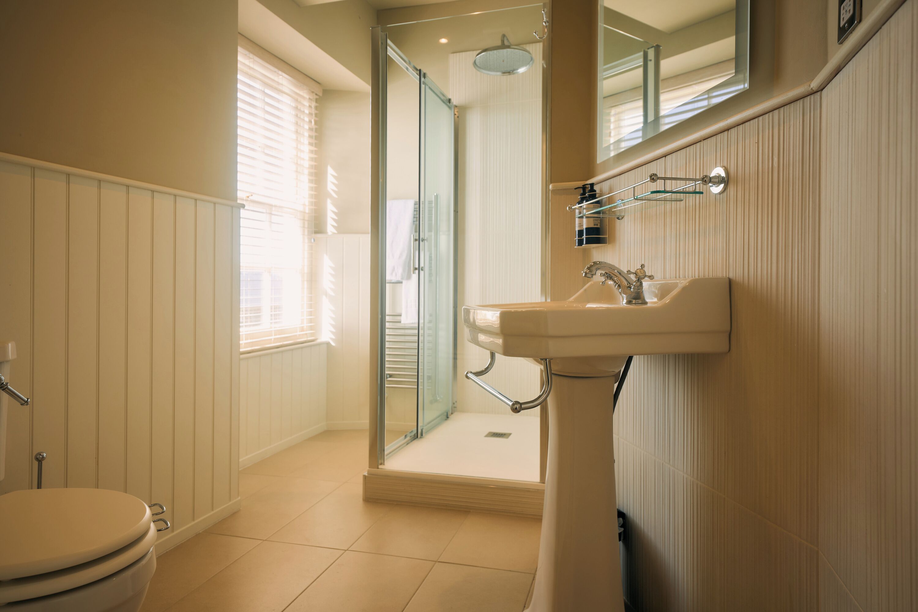 Een badkamer met toilet, wastafel en douche.