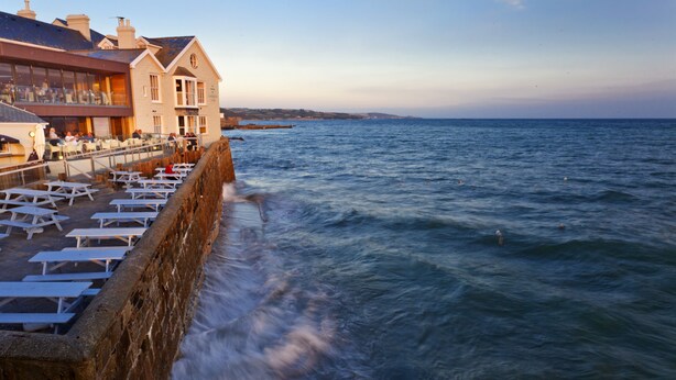 A coastal hotel with outdoor seating overlooking the sea. - The Godolphin (Marazion)