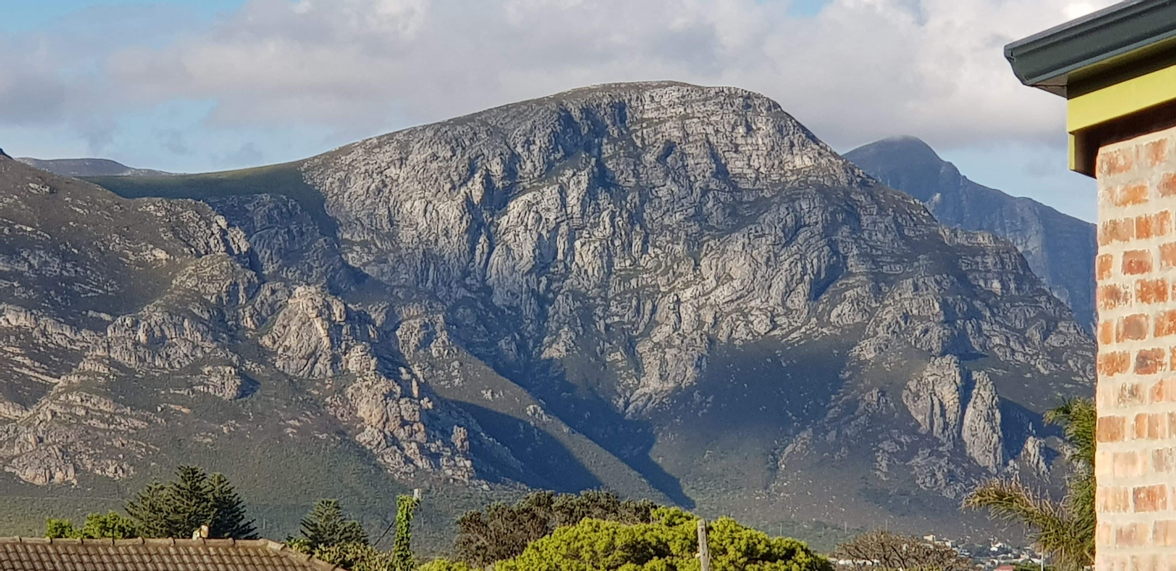 Une montagne à la surface accidentée et rocheuse, sous un ciel dégagé.