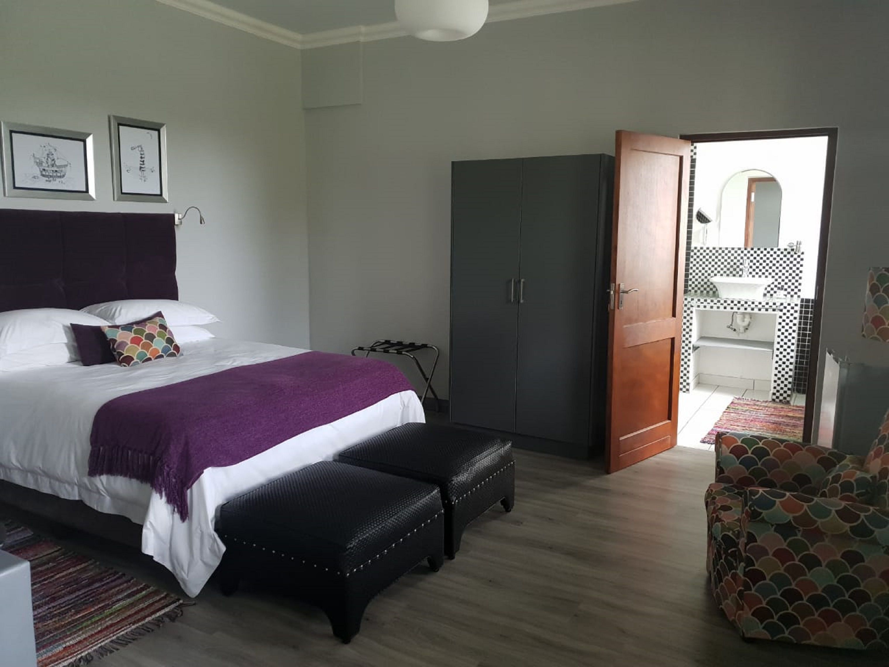 A bedroom with a bed, a wardrobe, a bench, and a chair.