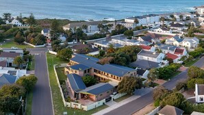 Vista aérea de una zona residencial con casas, calles y una masa de agua.