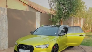 A yellow Audi RS4 parked in front of a house with a tiled driveway and a tree in the background. - Rosebank Accommodation (Johannesburg)