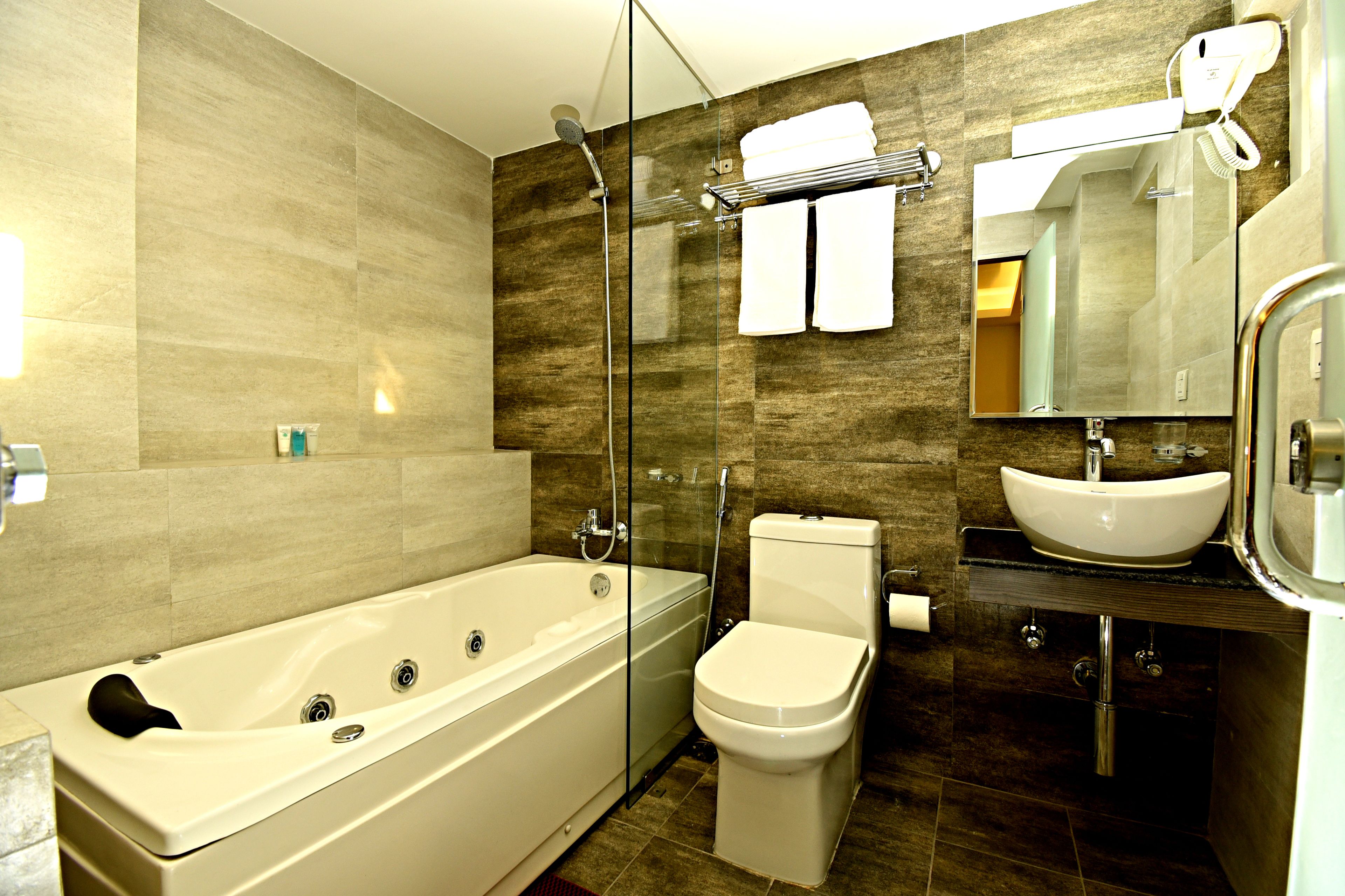 deluxe suite | bathroom | shower, rainfall showerhead, slippers, towels