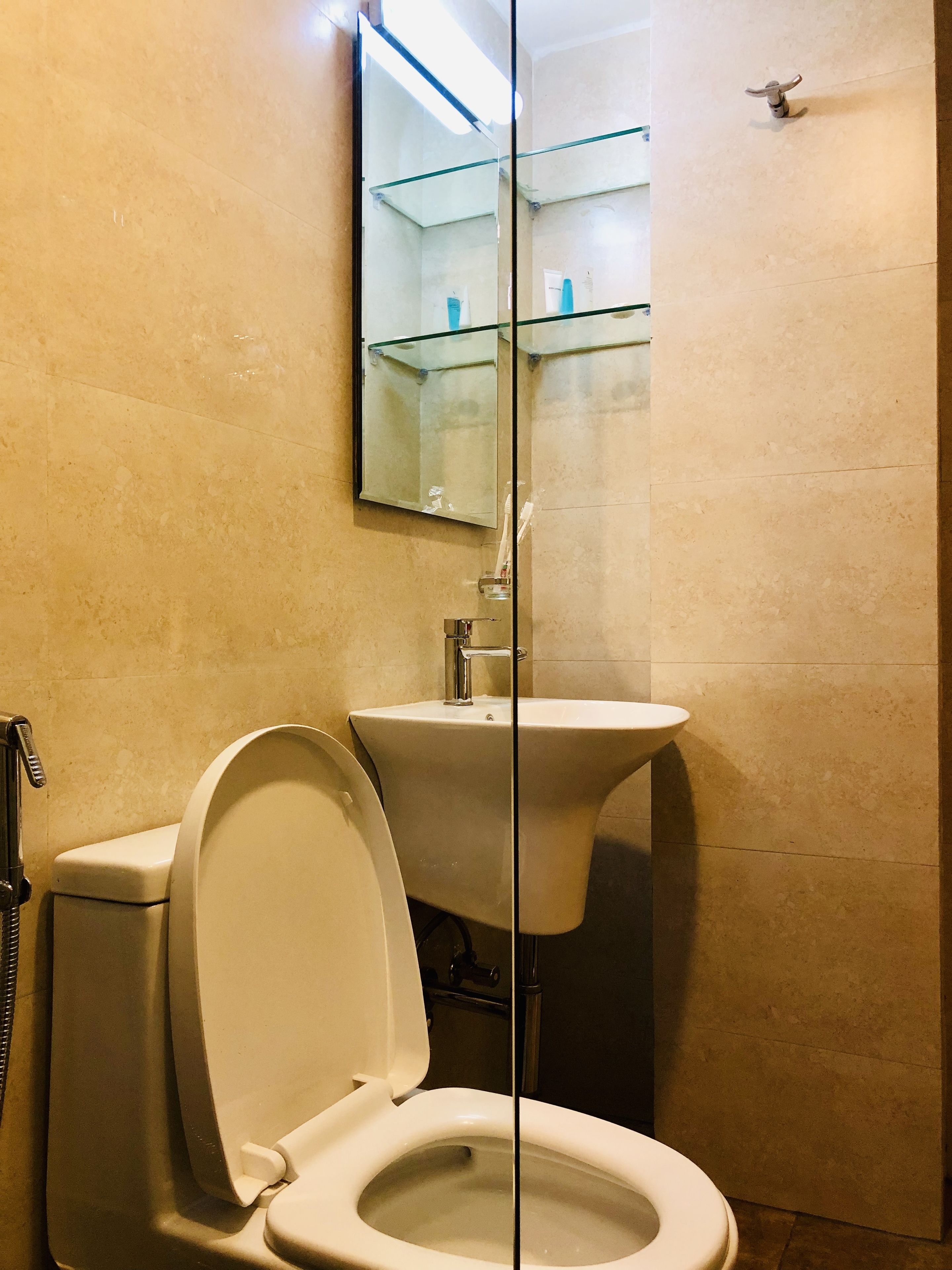 Un baño con inodoro, lavamanos y cabina de ducha de vidrio.