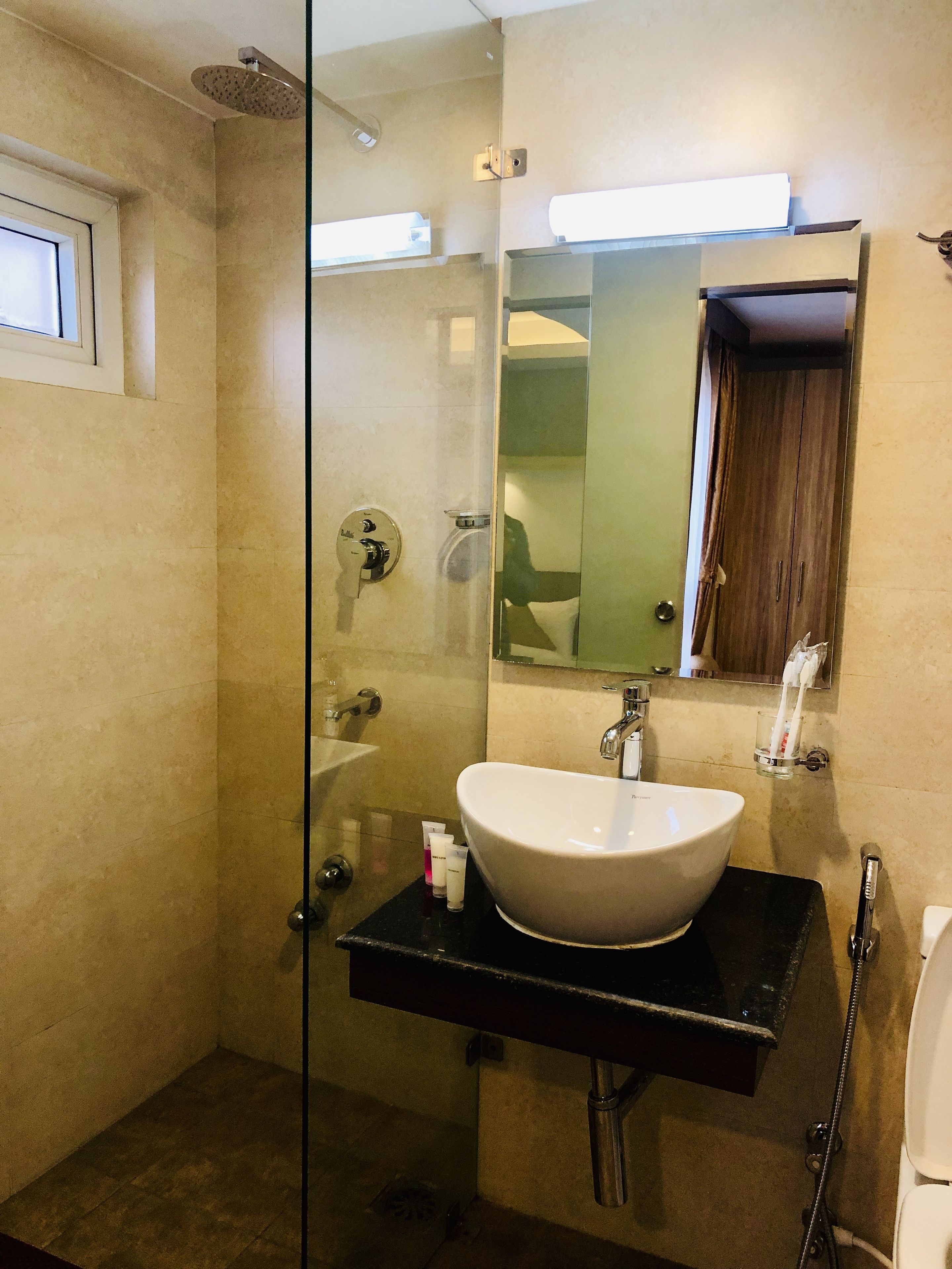 deluxe single room | bathroom | shower, rainfall showerhead, slippers, towels