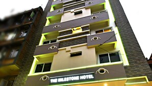 Et hotel med flere etager, med et tydeligt skilt der siger "The Milestone Hotel".