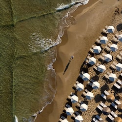 En la playa, playa de arena blanca, camastros y sombrillas