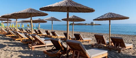 Plage, sable blanc, chaises longues, parasols