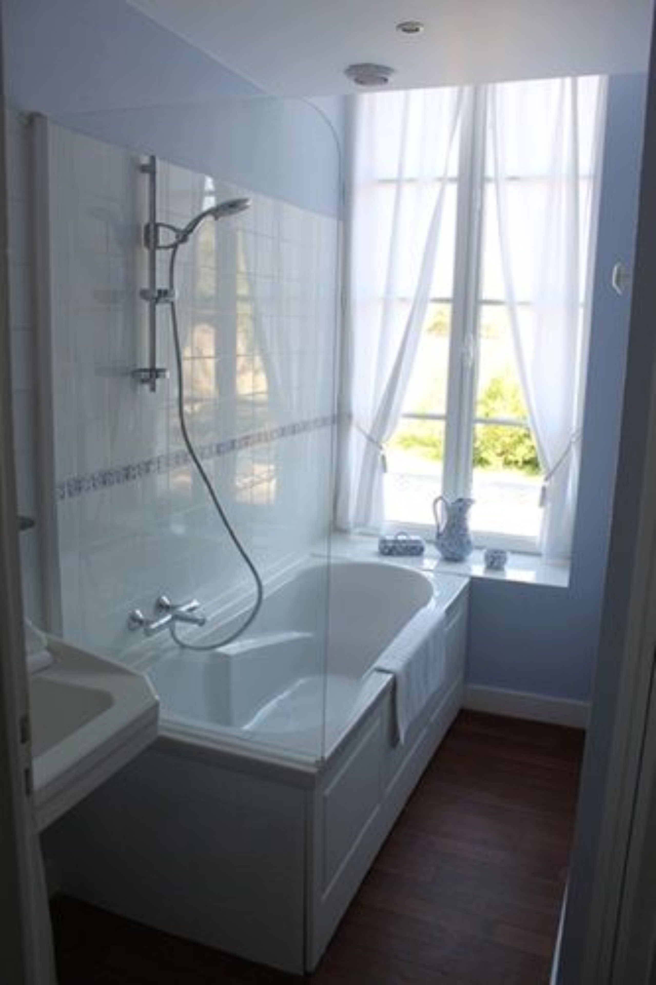 Une salle de bain avec une baignoire, une douche et un lavabo.