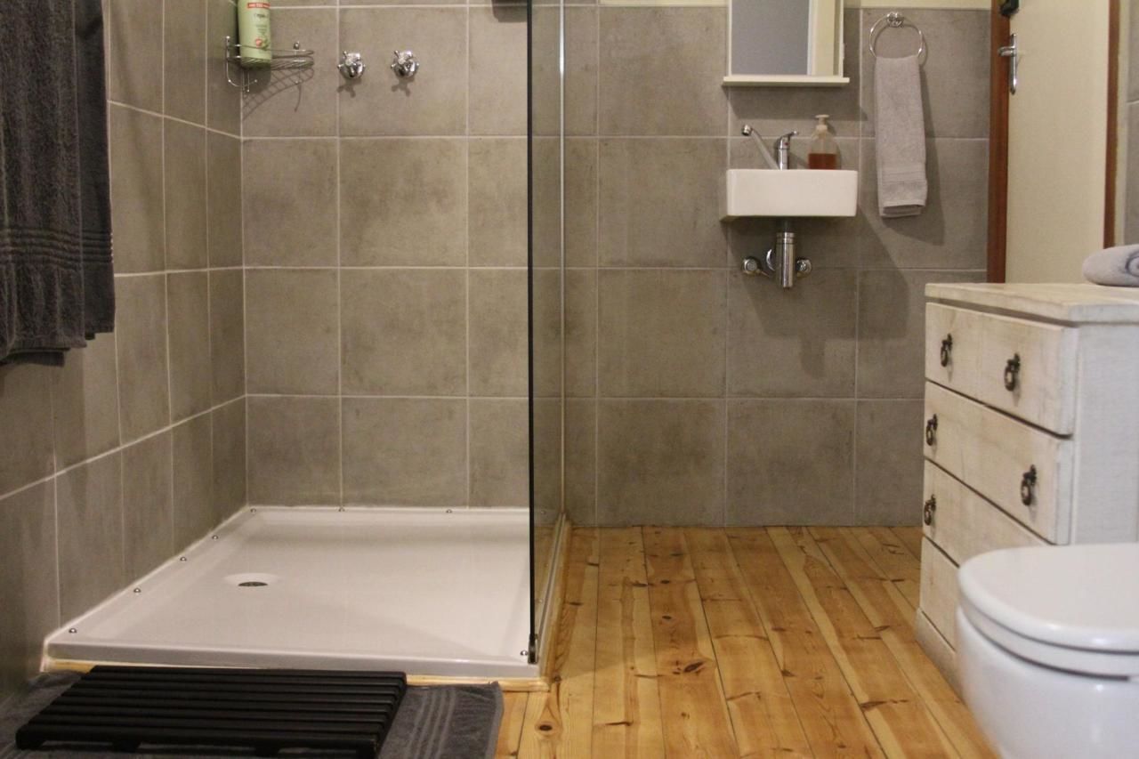 A bathroom with a shower, sink, and toilet.