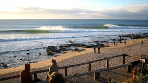 A beach with a wooden boardwalk, waves, and people. - Ripple Hill Hotel (Patensie)