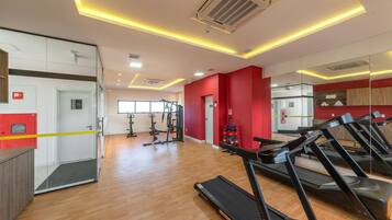 A modern gym with treadmills, exercise equipment, and a glass door entrance.
