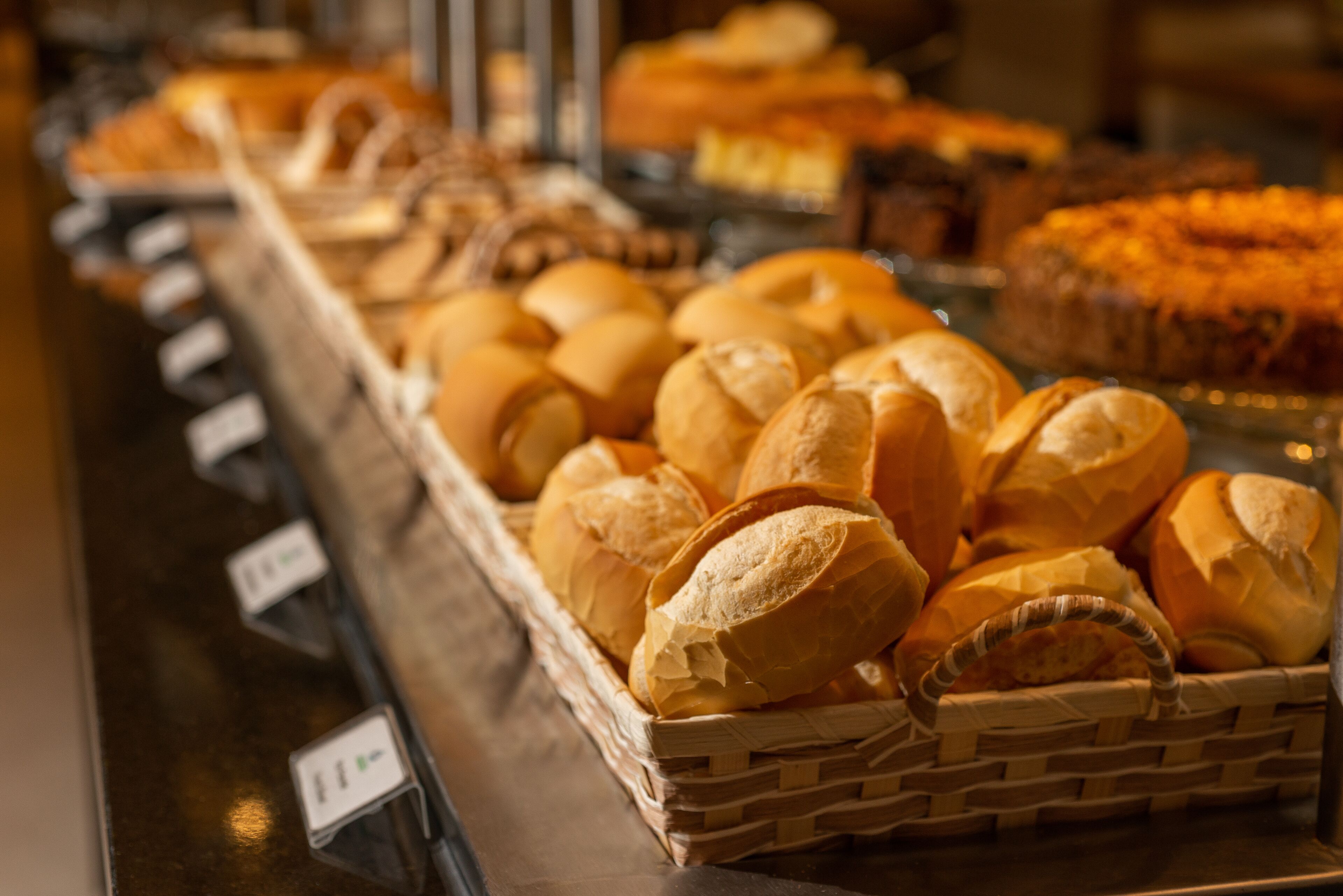 Una vitrina de panadería con distintos tipos de pan y pasteles.
