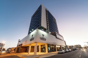 Um hotel moderno com entrada destacada e estrutura imponente.
