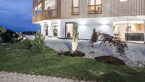 A modern multi-story building with a wooden facade, large windows, and a balcony. - Hotel Ambet (Rio di Pusteria)