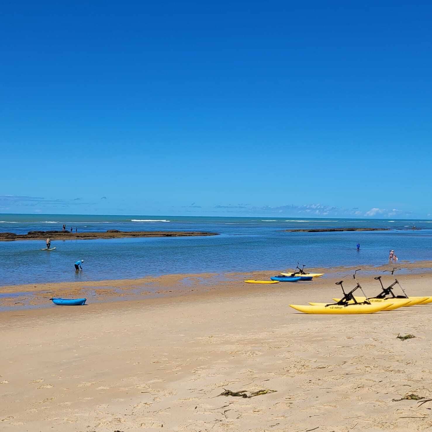 Une plage avec des kayaks et une côte rocheuse.