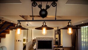 A modern living room with a fireplace, a TV, and a dining area. - Siangge Chuanfan Rock Resort (Hengchun)