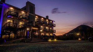 A multi-story hotel with balconies and a well-lit entrance. - Siangge Chuanfan Rock Resort (Hengchun)