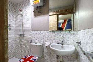 A bathroom with a shower, toilet, sink, and a mirror. - Kamariska Hostel (Sidoarjo)