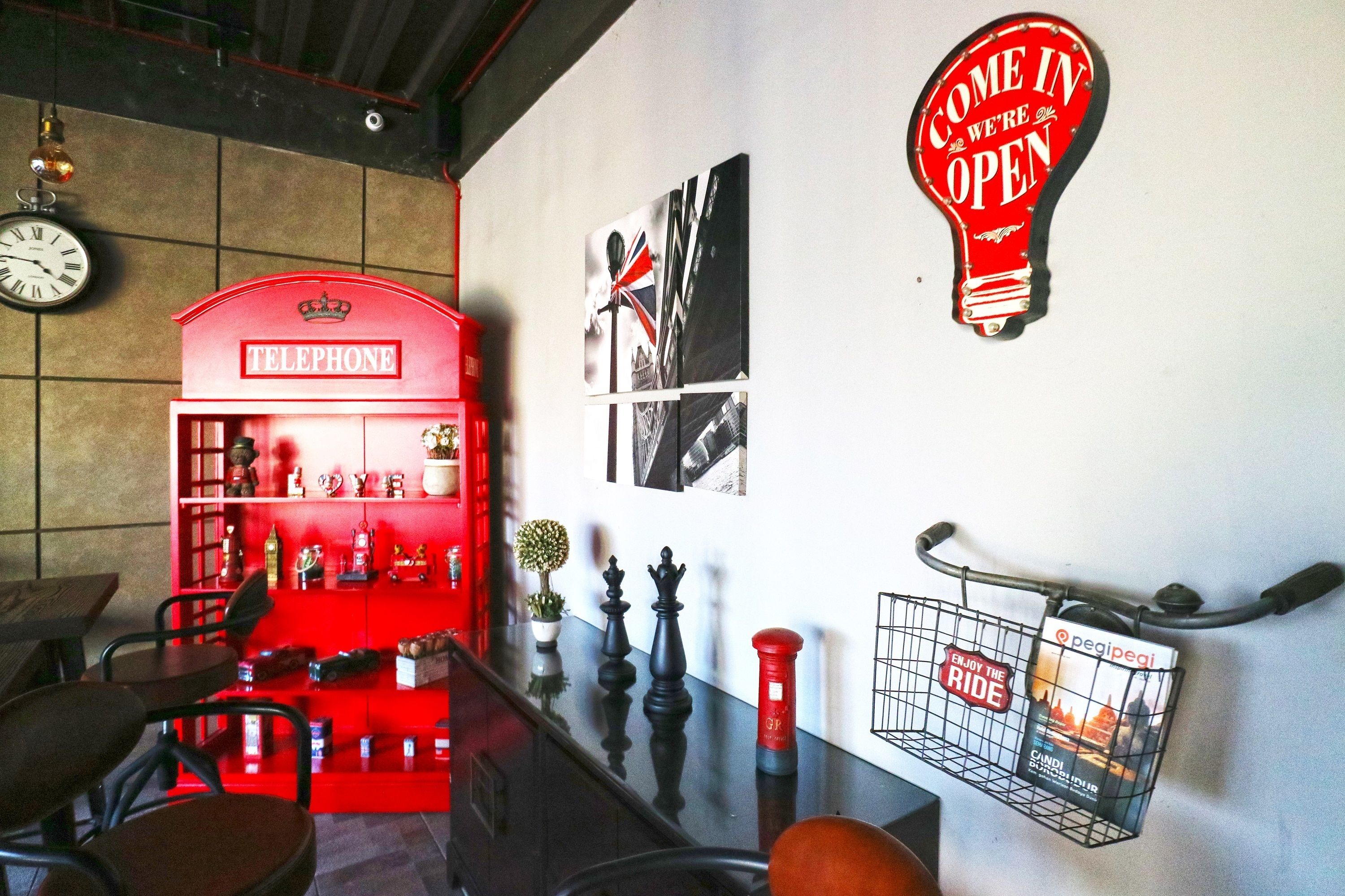 A red telephone booth, a wall clock, and a 'Come in we're open' sign.