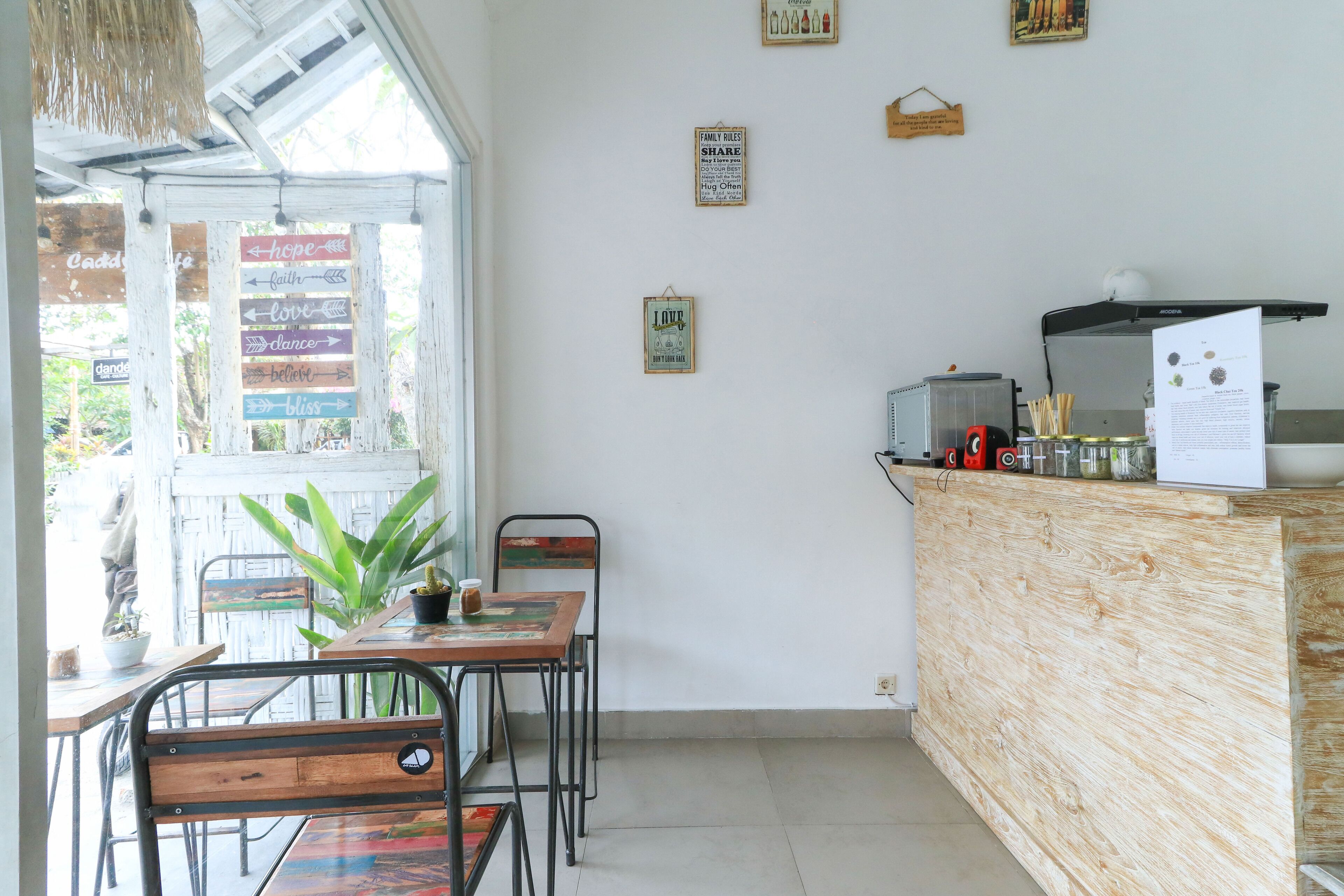 A restaurant interior with a wooden counter, metal chairs, and a large window.