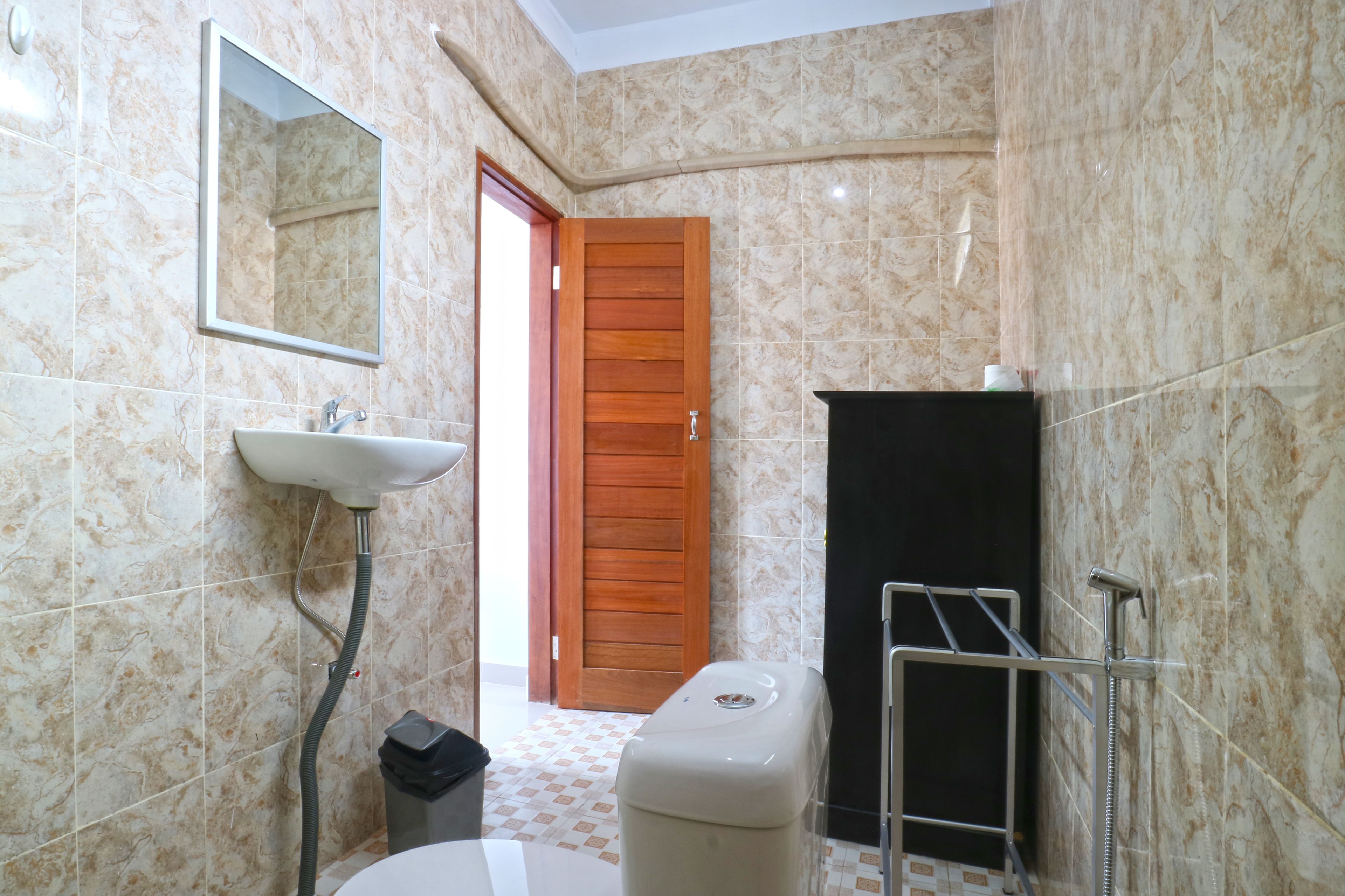 A bathroom with a sink, mirror, shower, and toilet.