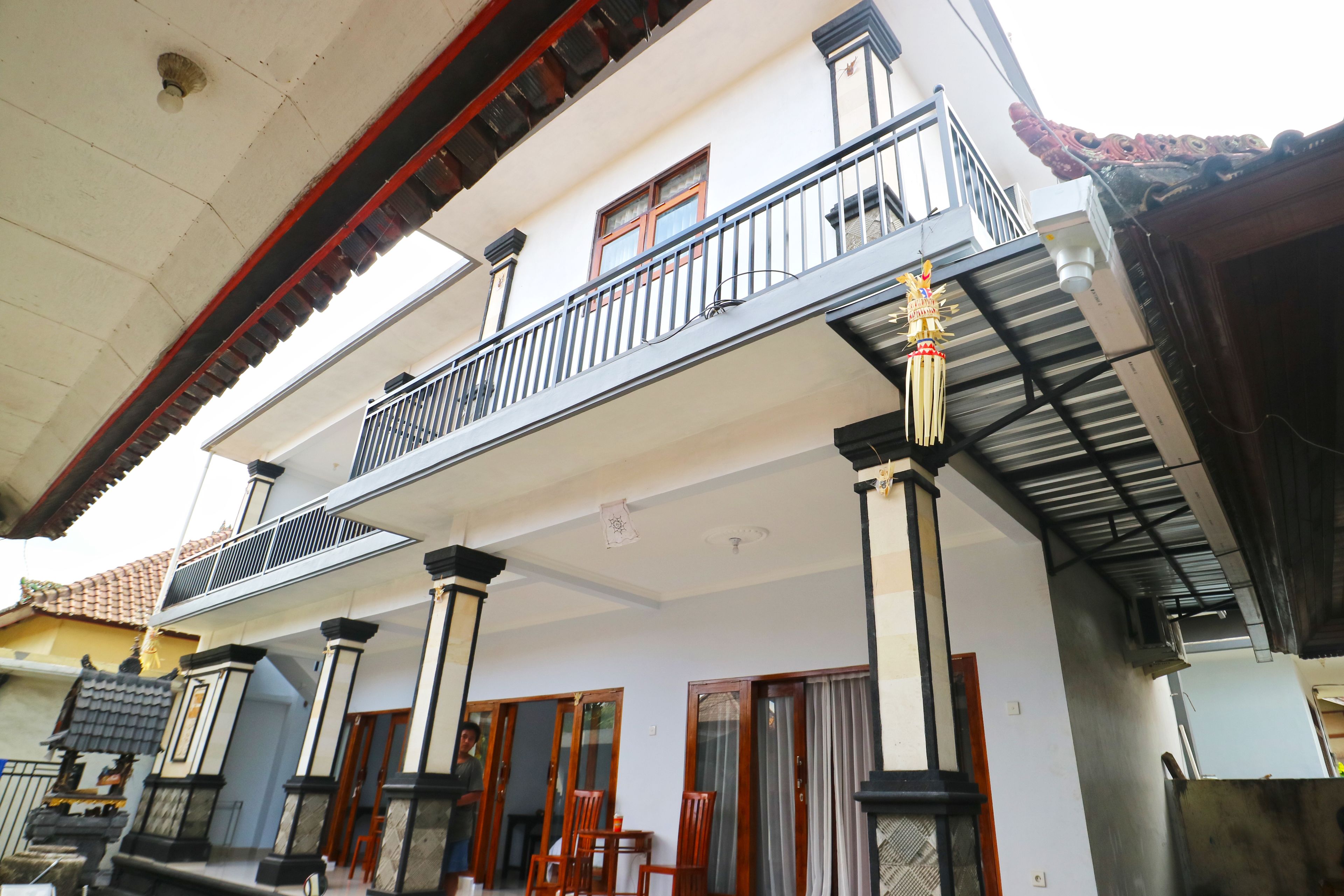 Un bâtiment à deux étages doté d’un balcon, de grandes fenêtres et d’un style architectural traditionnel.