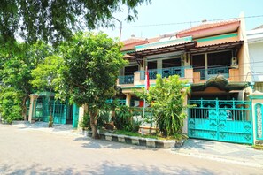 A two-story building with a balcony, a gated entrance, and surrounding greenery. - Hotel Shabine (Surabaya)