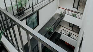 A multi-level interior with balconies, potted plants, and a modern architectural design.