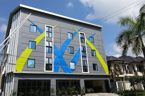 A multi-story building with a modern design, featuring a geometric pattern on the facade and multiple windows. - D' Paragon Bukit Dieng (Malang)