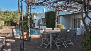 A patio with a pool, outdoor seating, and a pergola. - Maison Fougere (Franschhoek)