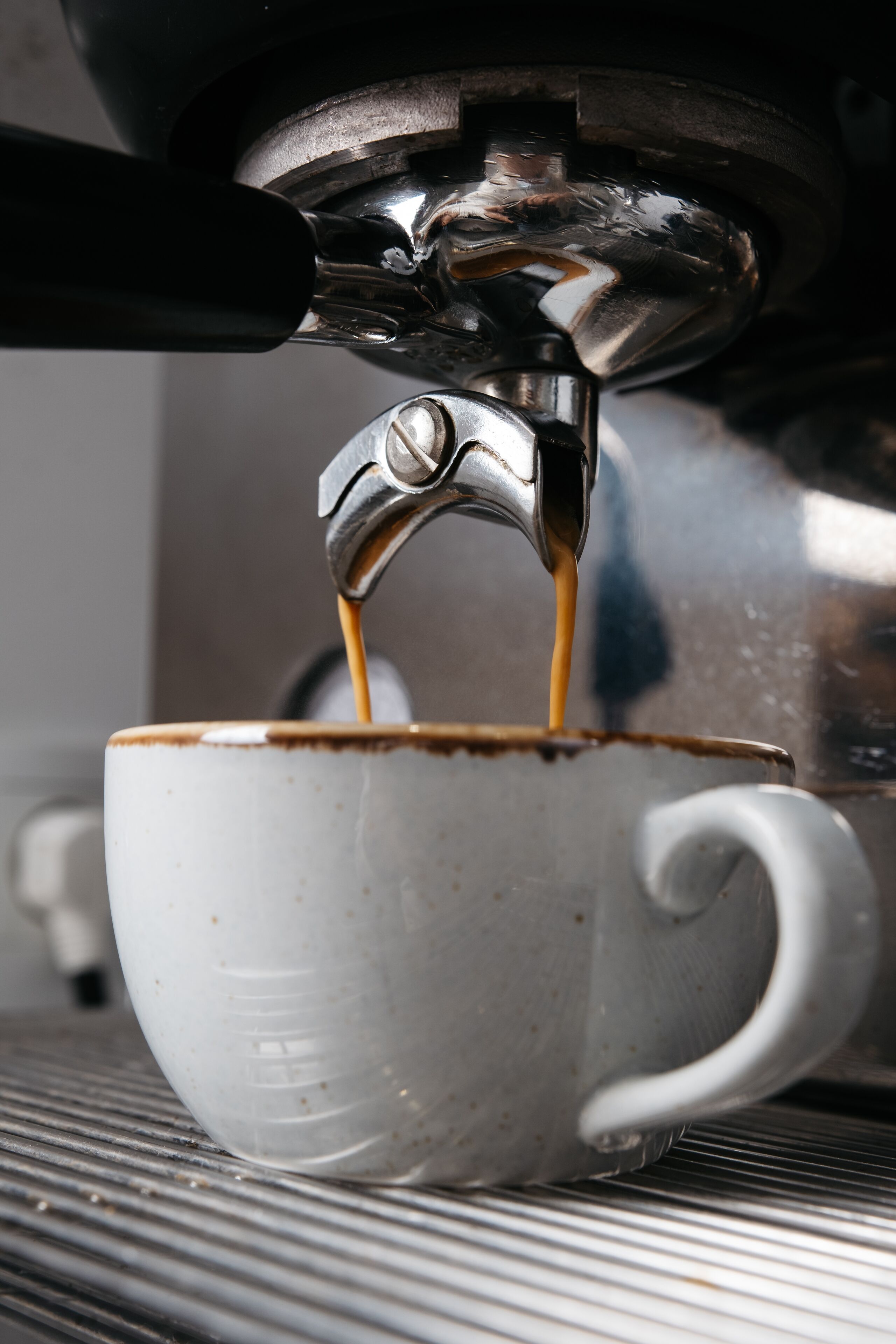 Primer plano de una máquina de café sirviendo un espresso en una taza.