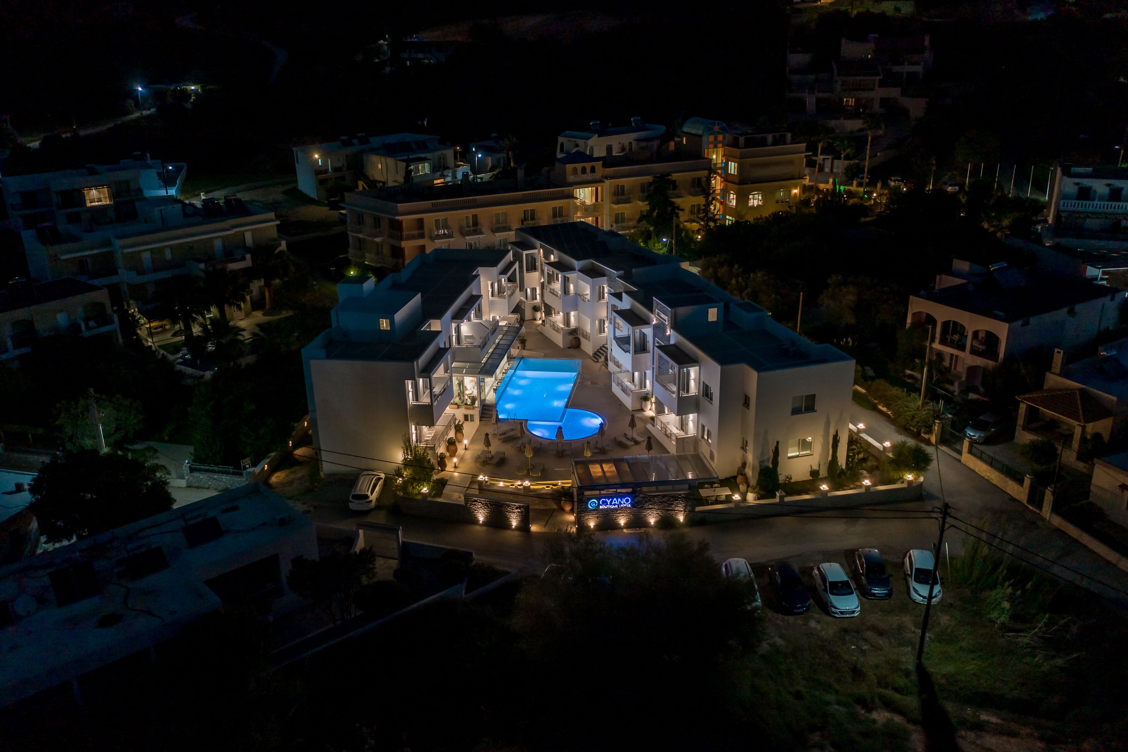 Vue aérienne d’un hôtel doté d’une piscine, de nombreux balcons et d’une entrée bien éclairée.