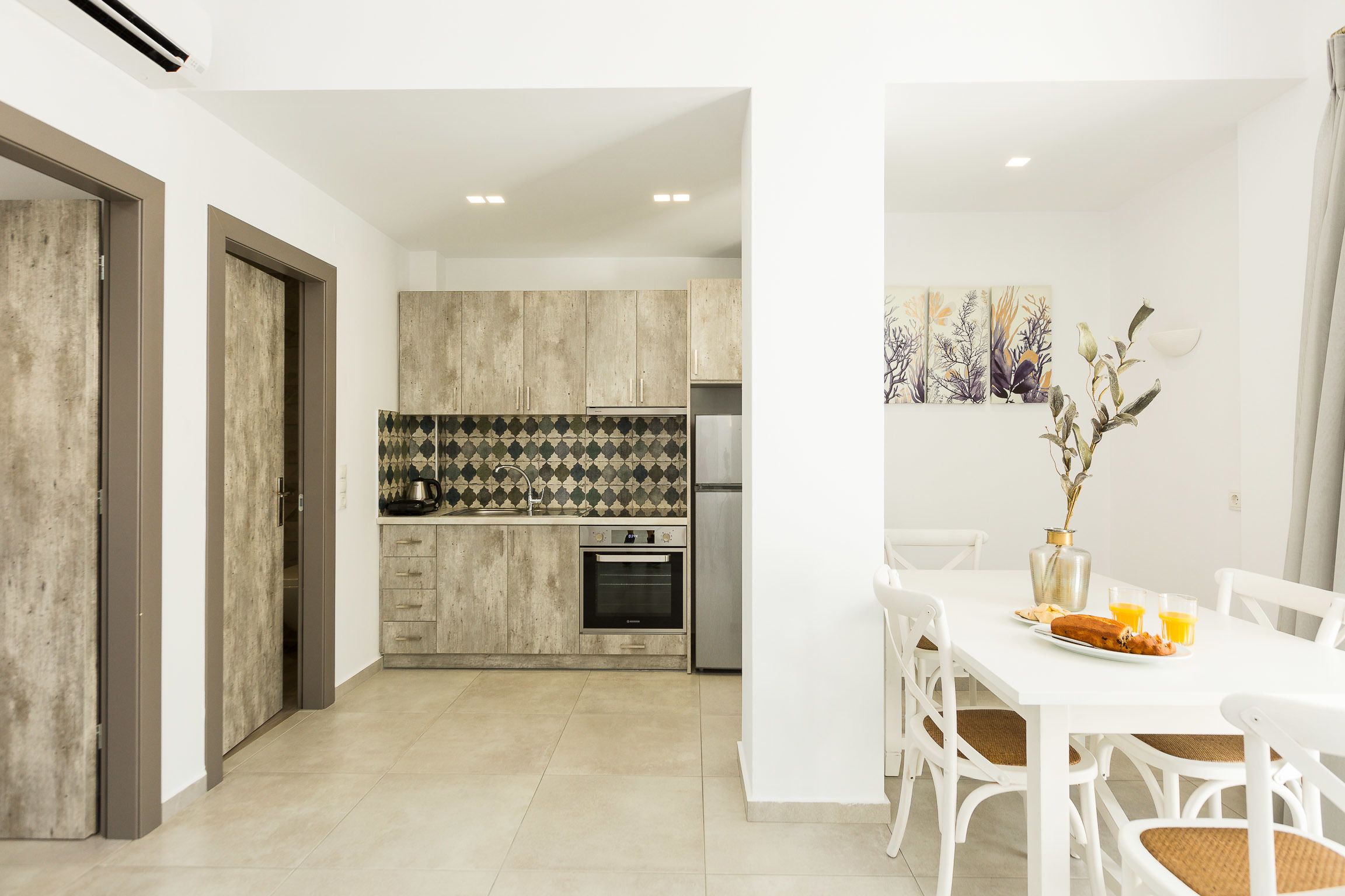 A modern kitchen with a central island, built-in oven, and stainless steel appliances.