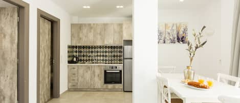 A modern kitchen with a central island, built-in oven, and stainless steel appliances.