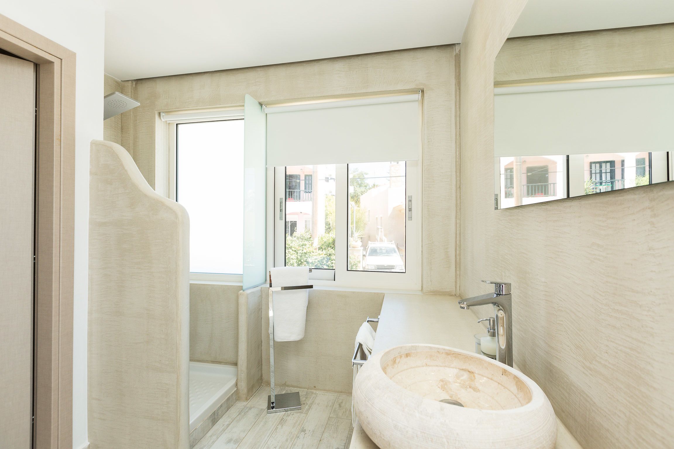 Une salle de bain moderne dotée d’une grande fenêtre, d’une baignoire et d’un lavabo.
