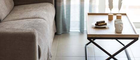 A living room with a sofa, a coffee table with decorative items, and a plate of food.