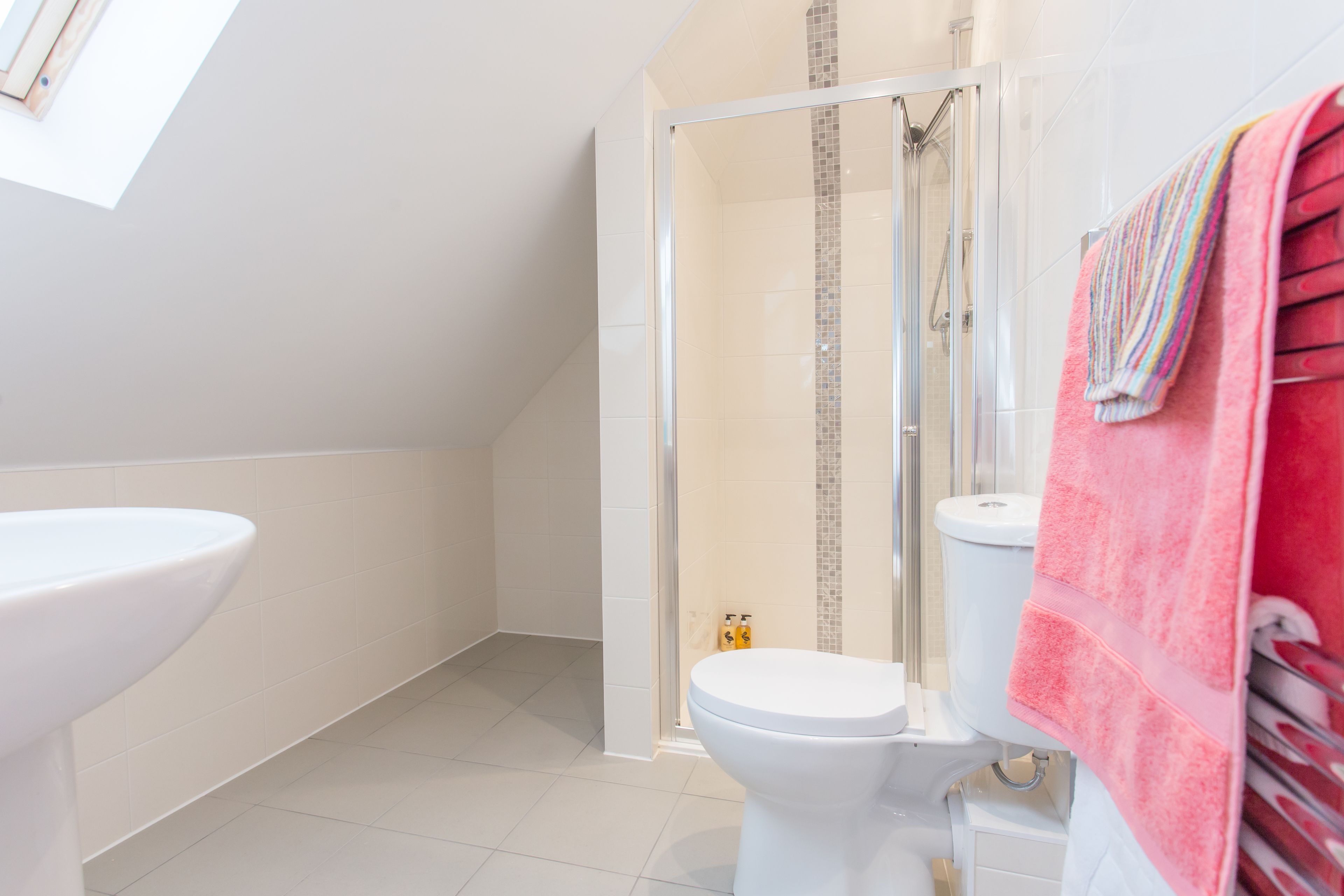 Un baño moderno con ducha, inodoro y lavamanos.