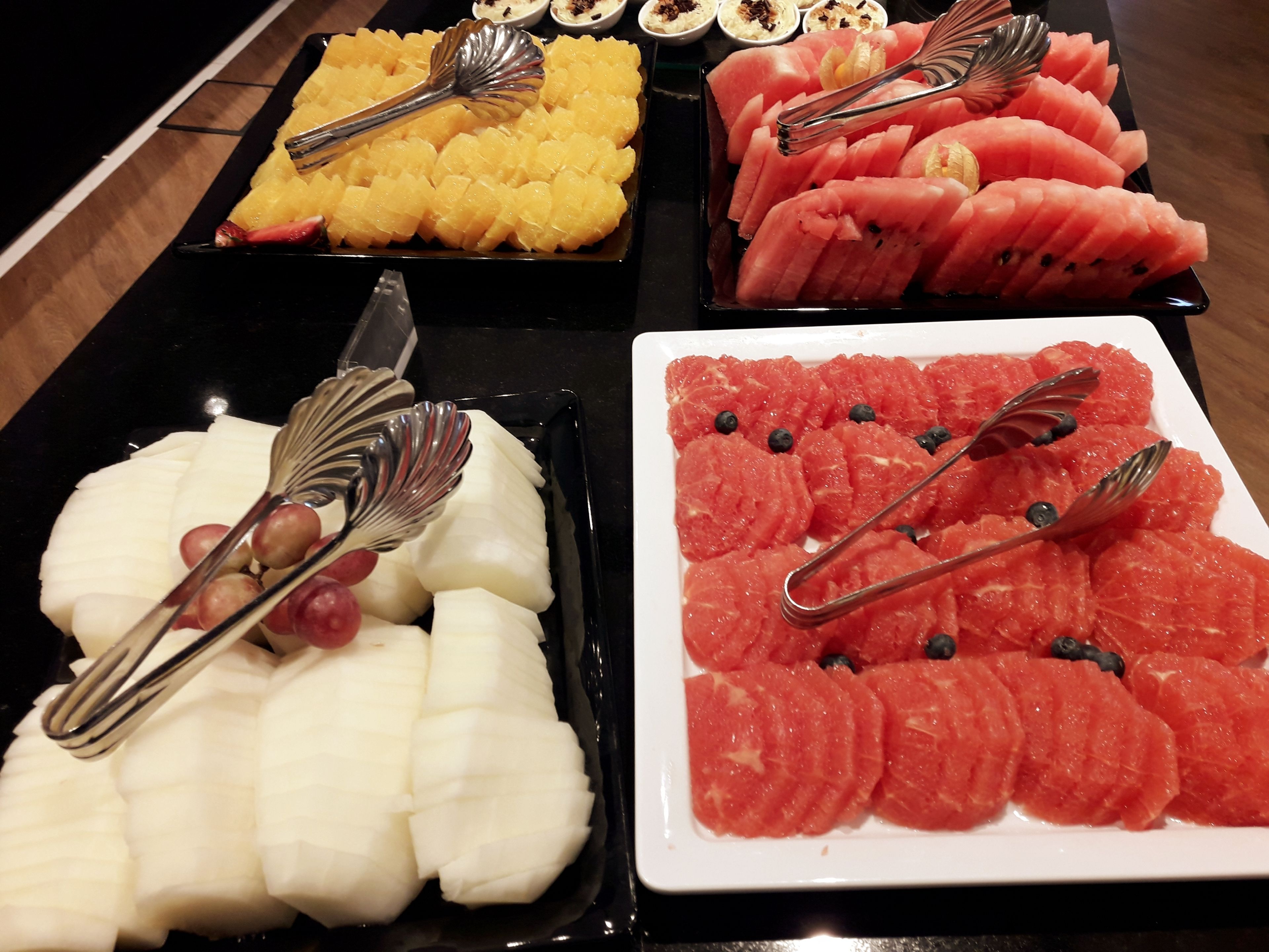 A buffet with various fruits and a knife.
