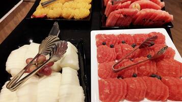 A buffet with various fruits and a knife.