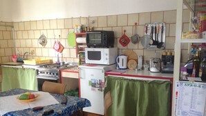 A compact kitchen with a stove, microwave, refrigerator, and various kitchen utensils. - B&B Relax (Miane)