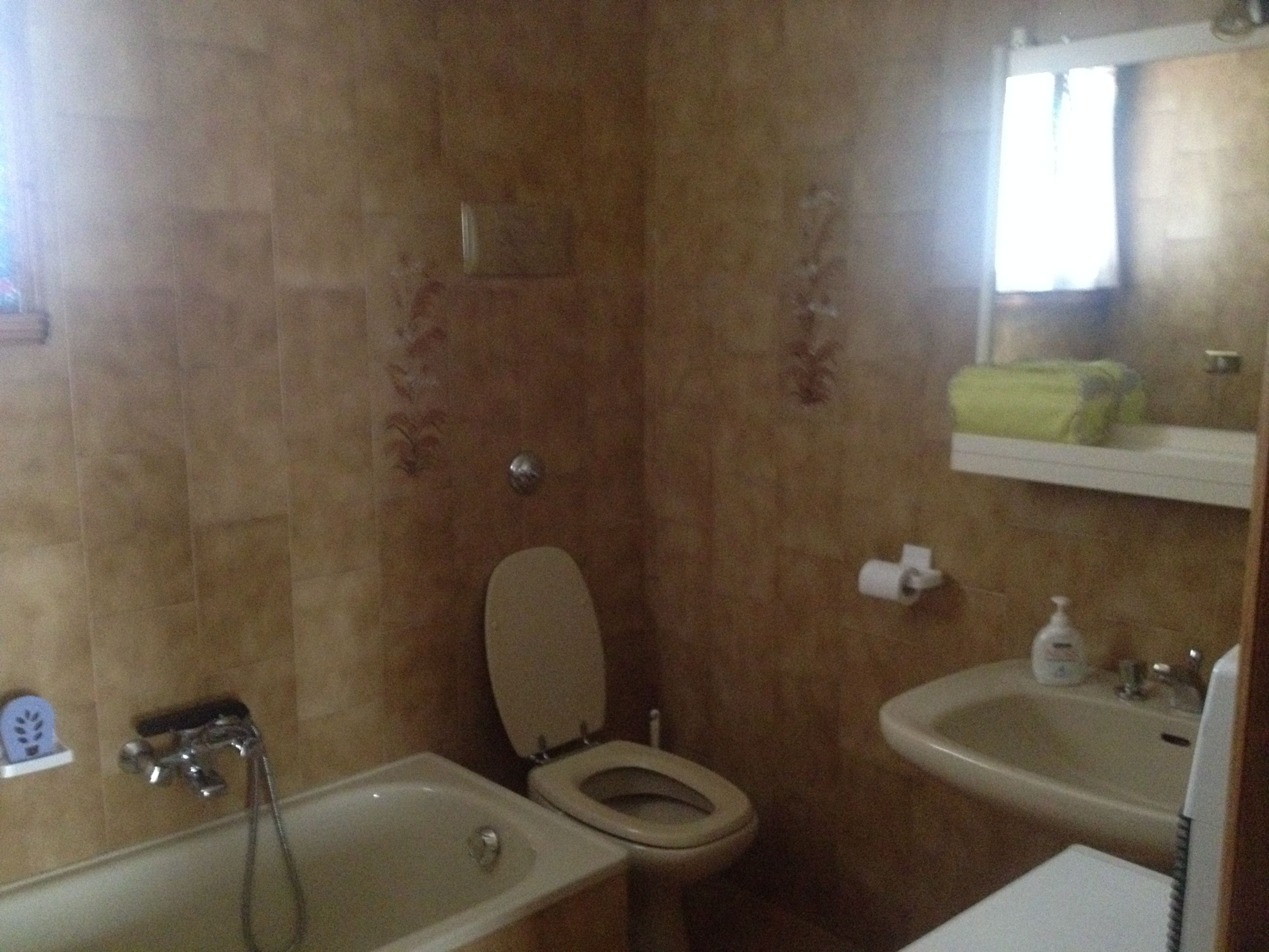 A bathroom with a bathtub, toilet, and sink.