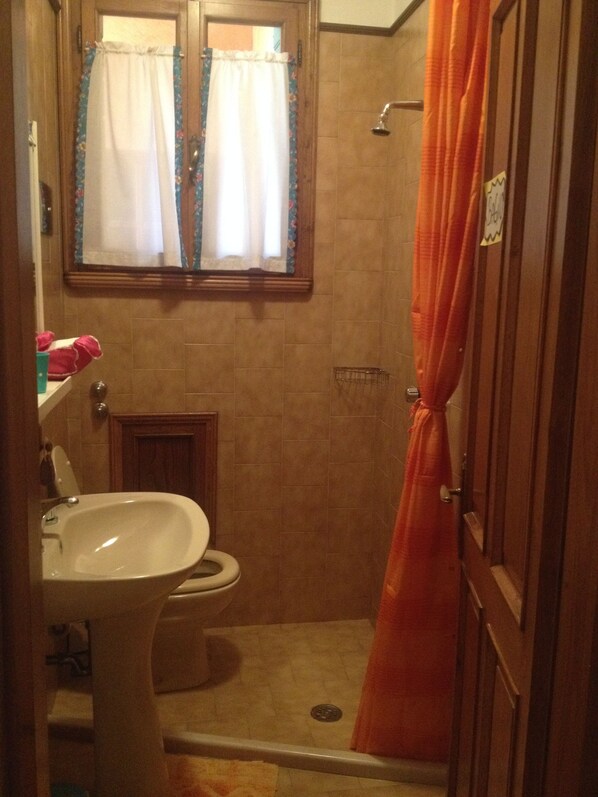 A small bathroom with a toilet, sink, and shower. - B&B Relax (Miane)