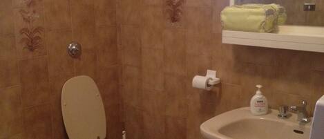 A bathroom with a toilet, bathtub, sink, and a mirror.