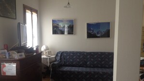 A living room with a sofa, a small table, a lamp, and two framed pictures on the wall. - B&B Relax (Miane)