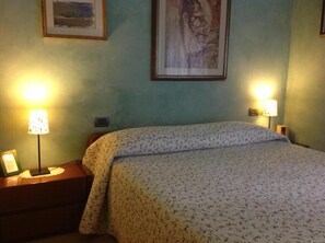 A room with a bed, two bedside lamps, and two framed pictures on the wall. - Bed & Breakfast La Casa Delle Rondini (Staffolo)
