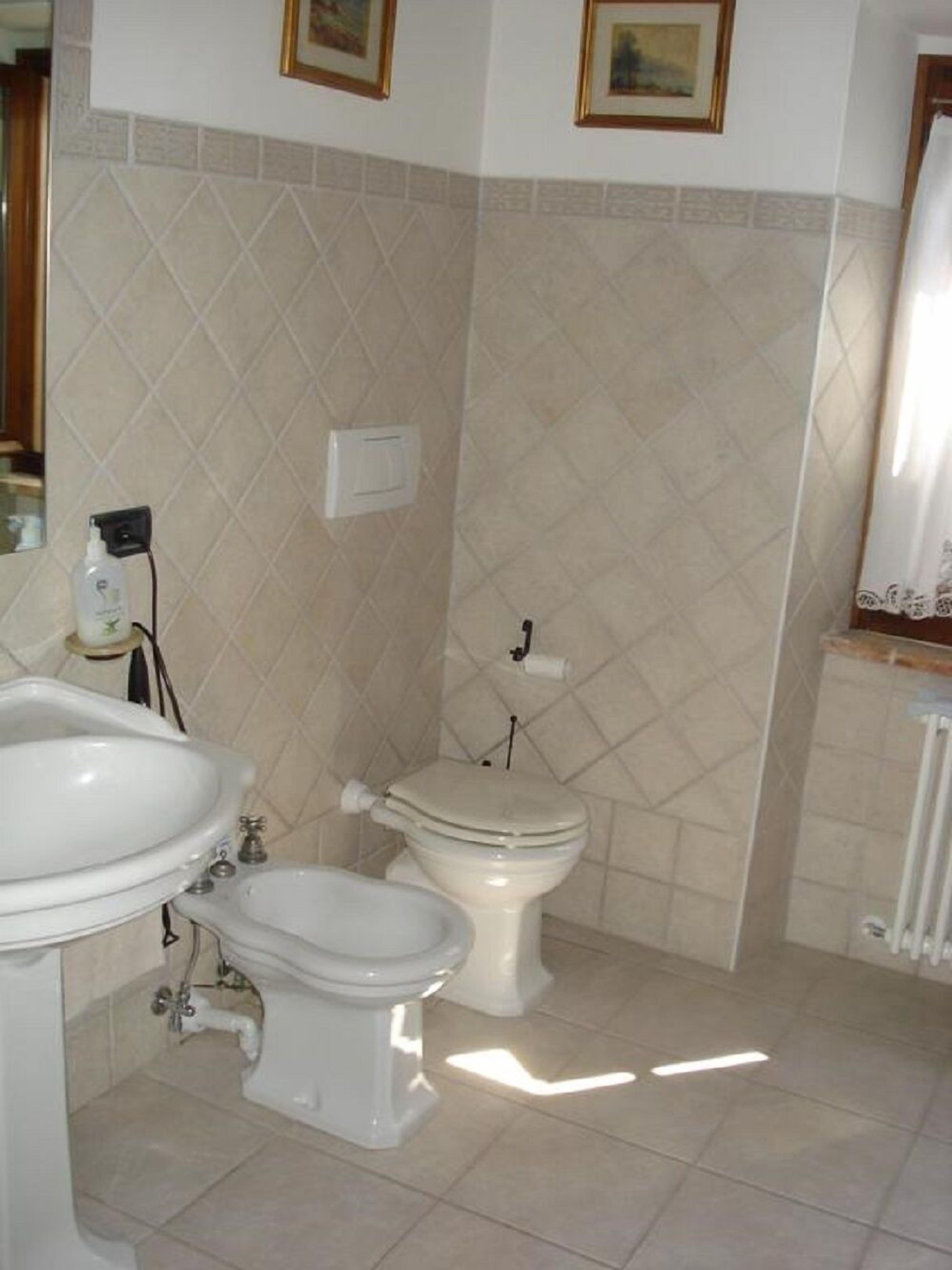 Un baño con lavamanos, inodoro, bidé y zona de ducha.