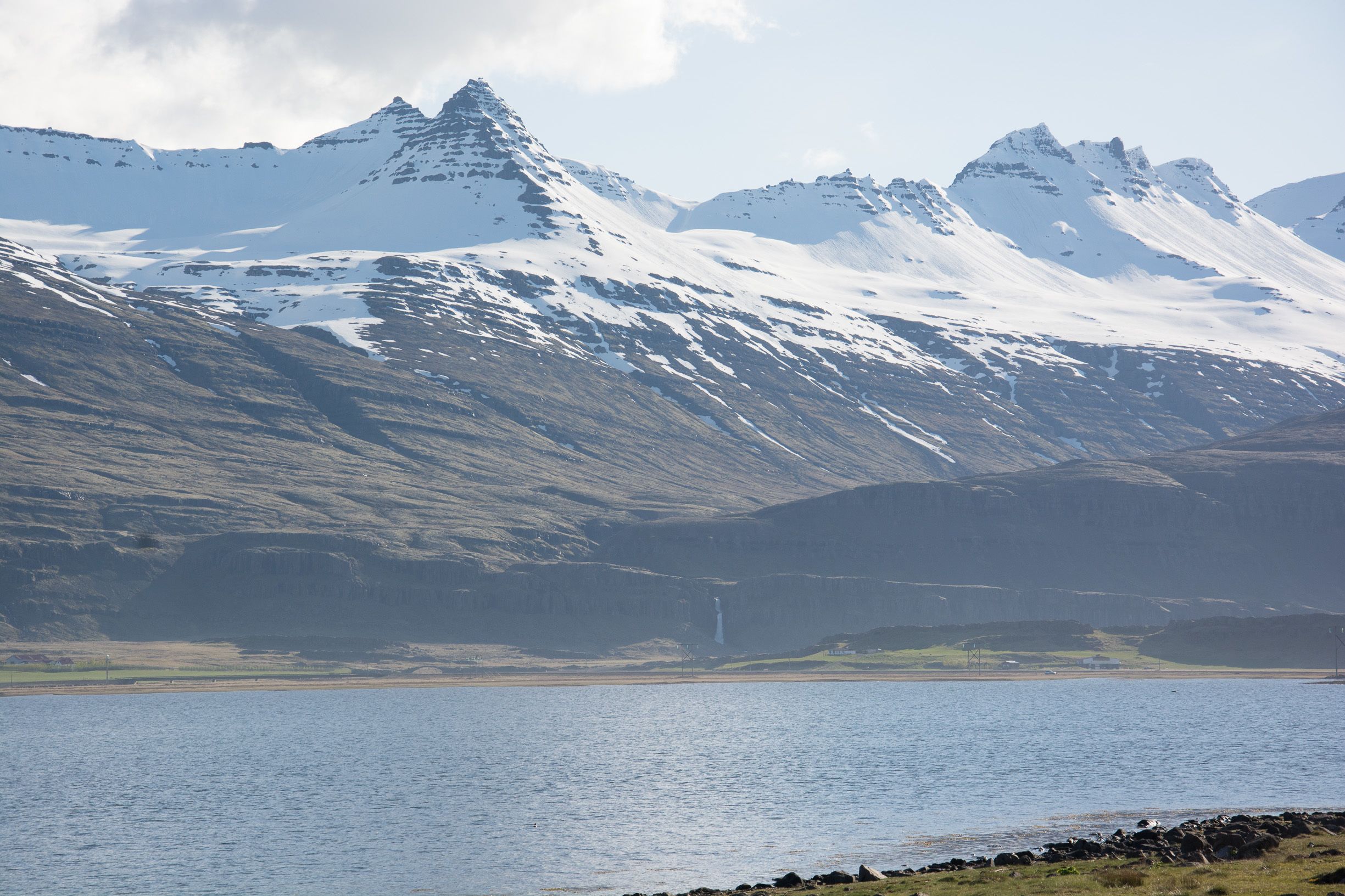 Un paysage montagneux avec un lac et une cascade.