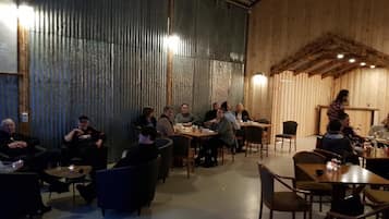Un restaurante con paredes y mesas de madera, donde hay personas sentadas comiendo.